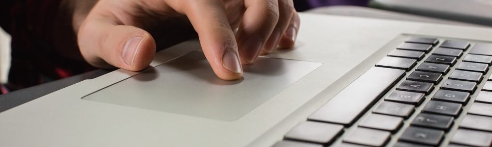 Hand of man using laptop in bar